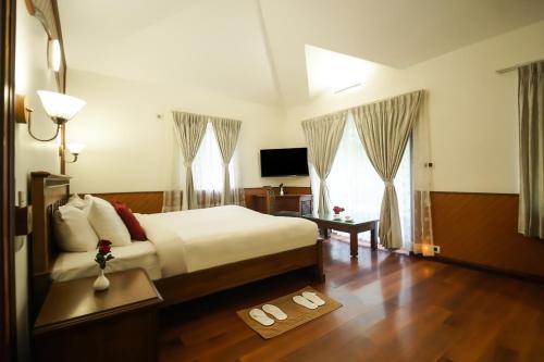 a bedroom with a bed and two slippers on the floor at JC Residency in Kodaikānāl