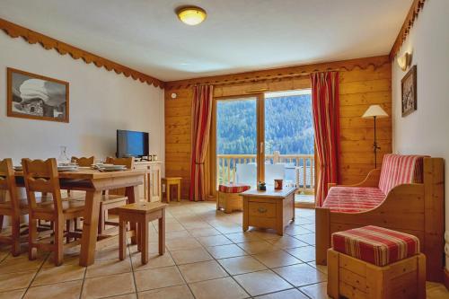 ein Wohnzimmer mit einem Esstisch und einem TV in der Unterkunft Quillis vue Montagne, Spa & Terrasse in Champagny-en-Vanoise