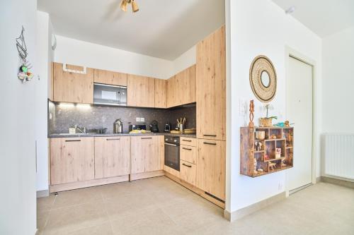 a kitchen with wooden cabinets and a wall at Namasté - Idéal familles - Terrasse - Garage - Mer in Six-Fours-les-Plages