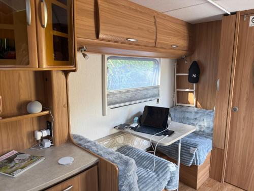a small room with a laptop on a desk in a caravan at Beach Bum Caravan in Caparica