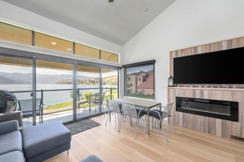 a living room with a television and a table and chairs at Lake Chelan Shores - Beachfront Sunsets #6-5 in Chelan