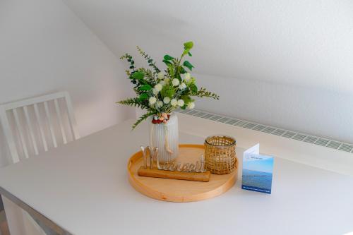 a vase of flowers sitting on a table with a card at Seemöwe in Friedrichsschleuse
