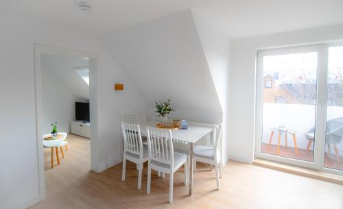 a white dining room with a white table and chairs at Seemöwe in Friedrichsschleuse