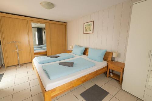 a bedroom with a large bed with blue pillows at Ferienhaus Nordseebude in Boostedt