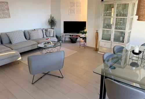 una sala de estar con un sofá y una mesa en LAUSANNE PULLY sunny apartment on lakeside street and direct bus to Lausanne train station, en Pully