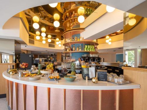 Un restaurante con un mostrador con comida. en Mercure La Rochelle Vieux Port, en La Rochelle