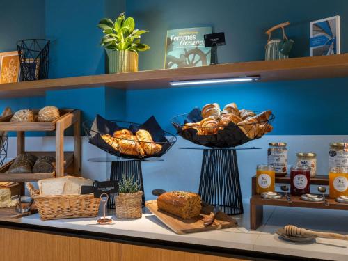 Un mostrador de panadería con cestas de pan y pasteles en Mercure La Rochelle Vieux Port, en La Rochelle