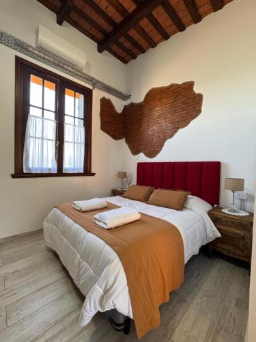 Un dormitorio con una cama grande con cabecero rojo. en Como Entonces Casa, en Uribelarrea