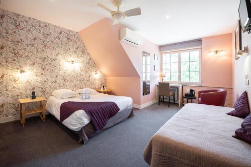 a hotel room with two beds and a window at Logis Hôtel Restaurant La Vieille Auberge, Art and Gallery in Souillac