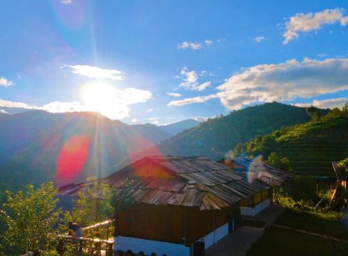 a house with the sun shining on a mountain at Mù Cang Chải Dream House in Mù Cang Chải