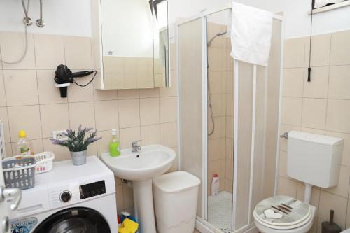 a small bathroom with a sink and a washing machine at Appartamento la casa di Lilli Anguillara Sabazia-Lago, Relax e Roma a portata di treno in Anguillara Sabazia