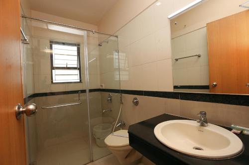 a bathroom with a sink and a shower and a toilet at Hotel Aishwaryaa in Erode