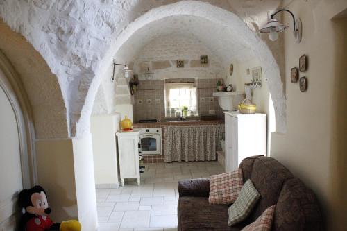 a living room with a couch and a kitchen at Trullo Galeotto in Martina Franca