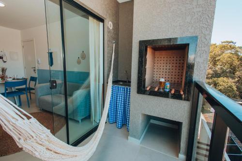 a room with a hammock in a house at Apto completo e charmoso para curtir a praia in Itapoa