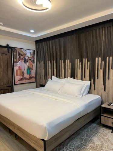 a bedroom with a large bed with a wooden wall at The Westbury Inn in Abuja