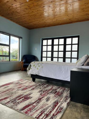a bedroom with a large bed and a rug at Lee Place in Maseru
