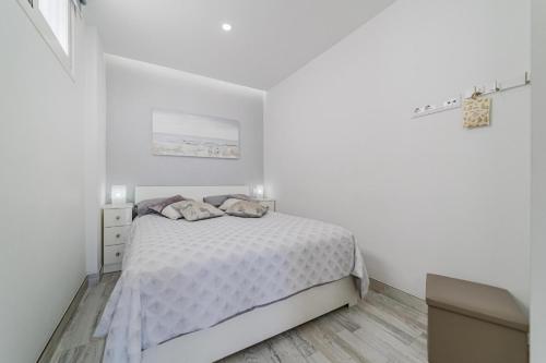 een witte slaapkamer met een bed en een ladekast bij El Sueño in Adeje