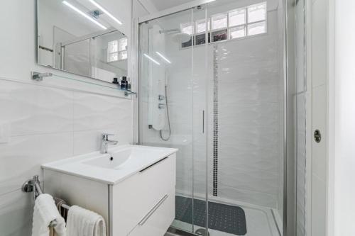 een witte badkamer met een wastafel en een douche bij El Sueño in Adeje