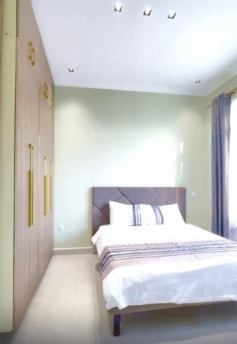 Un dormitorio con una cama grande con sábanas blancas. en Lacasa Homes, en Kampala