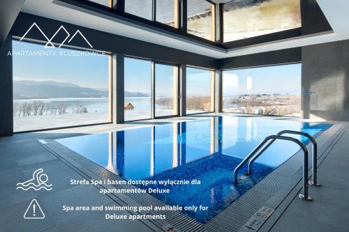 een zwembad in een gebouw met ramen bij Apartamenty nad jeziorem, Czorsztyn - Kluszkowce in Czorsztyn