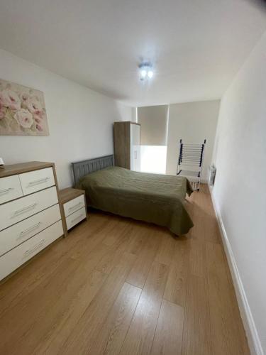 a bedroom with a bed and a wooden floor at York House Apartments in Romford