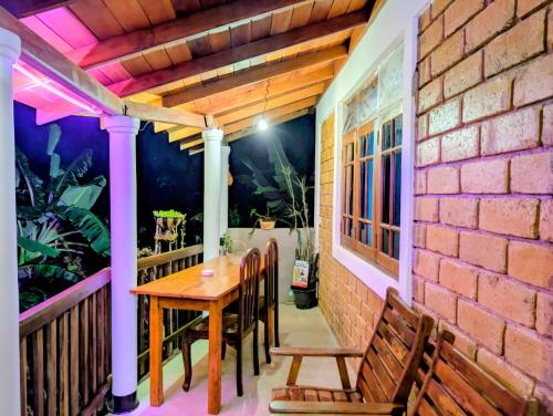 a patio with a wooden table and chairs on a brick wall at purple villa in Mirissa