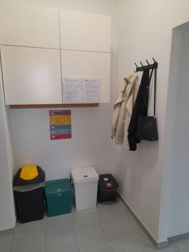 eine Küche mit zwei Mülleimern und einer weißen Wand in der Unterkunft Zambo's in Agrate Brianza