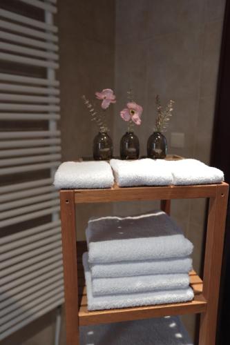 デイルベークにあるSpacious Villa in Dilbeek with Private Garden, Ideal for Families & Businessのタオルと花瓶の花が飾られた棚