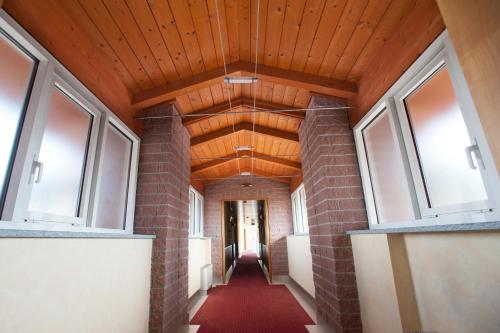 a hallway in a building with windows and a red carpet at AlbaResidence Masera26 in Alba