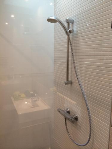 a shower with a sink and a shower head in a bathroom at Odeceixe Vila in Odeceixe