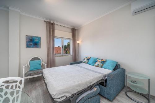 a small room with a bed and a chair at Beach Apartment On The Beach in Praia da Rocha