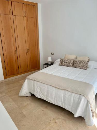 een slaapkamer met een groot bed en een houten kast bij Apartamento Centro con Aparcamiento in Santa Cruz de Tenerife