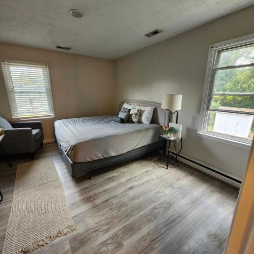 a bedroom with a bed and two windows at Daddy's Girl Bed & Breakfast in Richmond