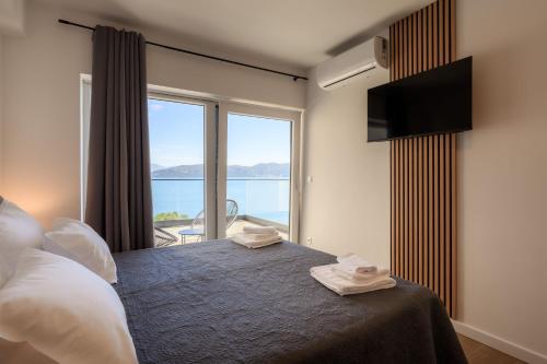 a bedroom with a bed with a view of the ocean at Villa Zvonimir in Sreser