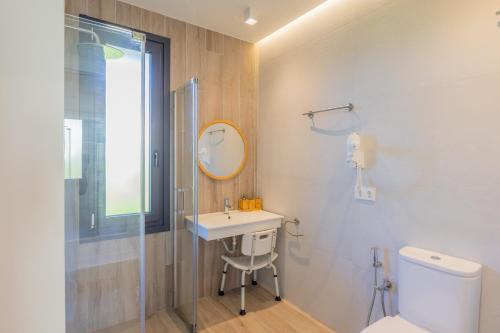 une salle de bain avec un lavabo, des toilettes et un miroir dans l'établissement OCEANSUITESLANGRE, à Galizano