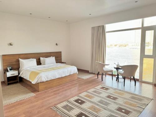 a bedroom with a large bed and a large window at Riverside Hotel in Cairo
