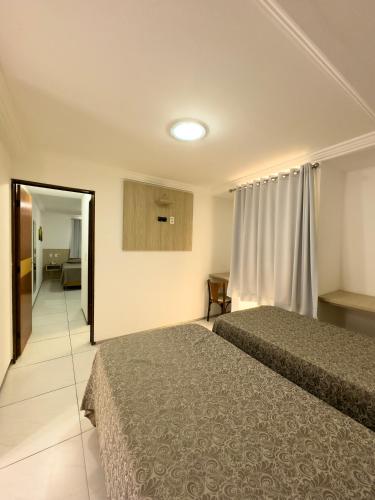 ein Hotelzimmer mit zwei Betten und einem Flur in der Unterkunft Annamar Hotel in João Pessoa