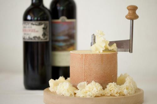 a bottle of wine and a cake with a knife at Hotel Edelweiss in Wengen