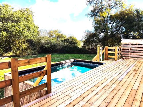 - une piscine sur une terrasse en bois avec une clôture dans l'établissement gite la bergerie, à Larressingle