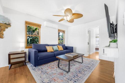 a blue couch in a living room with a ceiling fan at 2BR-2 mins to Ocean-Sleeps 8-Pets in San Diego