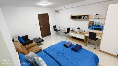 a bedroom with a blue bed and a living room at No 498 SPD in Phuket