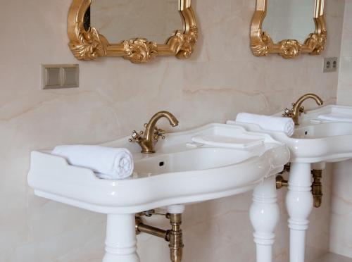 a bathroom with two sinks and mirrors on the wall at Zámek Jeseník Nad Odrou in Jeseník nad Odrou