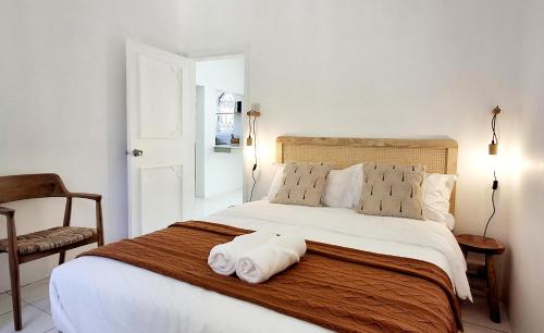 1 dormitorio con 1 cama y 2 toallas plegables. en Mermaid Cove - GARDEN, en Blue Bay