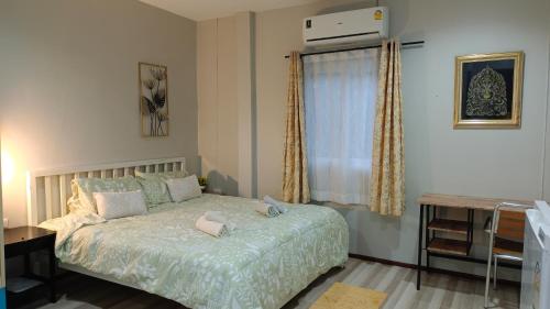 a bedroom with a bed and a window at B&N House in Nai Yang Beach