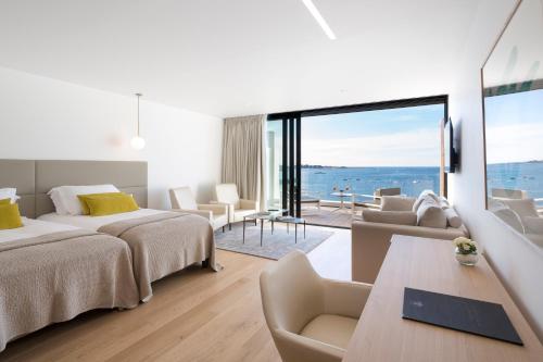 um quarto de hotel com duas camas e vista para o oceano em Relais & Châteaux Le Brittany & Spa em Roscoff