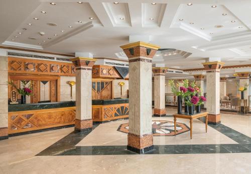 a lobby with pillars and flowers on a table at JAZ Pyramids Resort in Cairo