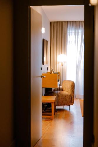 a living room with a chair and a desk in a room at Casa Zogbi Hotel in Porto