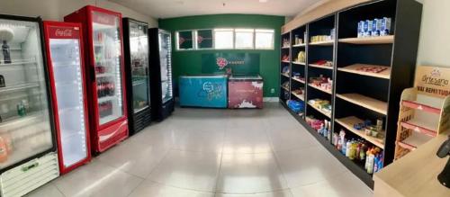 a store aisle with a refrigerator and shelves of food at Flat aconchegante 1307 in Fortaleza