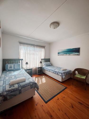 a large room with two beds and a couch at Aquarius Guesthouse in Jeffreys Bay