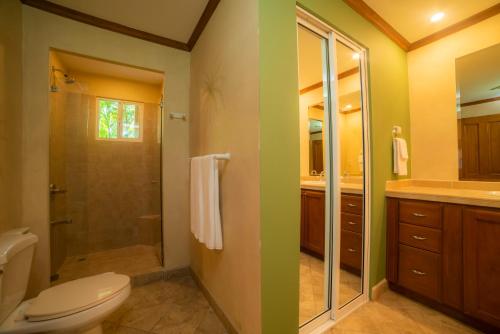 a bathroom with a toilet and a glass shower at Veranda 3G 2 bdr Garden View in Los Suenos in Jacó